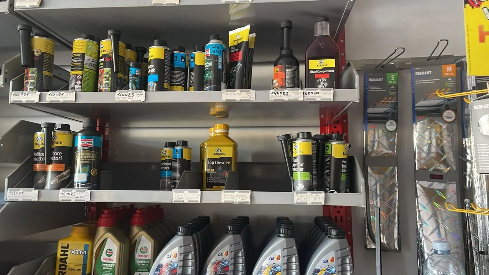 Uno scaffale del negozio con additivi, pulitori per iniettori e taniche di olio motore